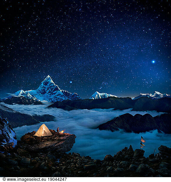 Starry sky over camper at bonfire overlooking sea of clouds and mountains  Pokhara  Kaski  Nepal