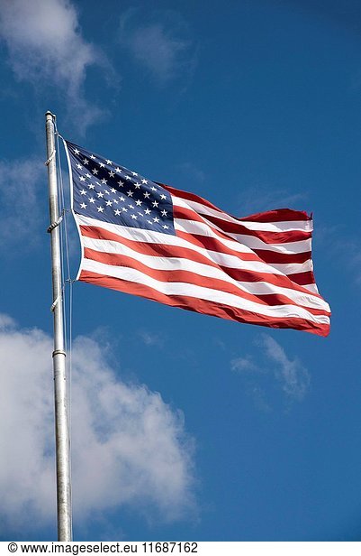 Stars and Stripes flag flying from a flagpole on a breezy day  USA.