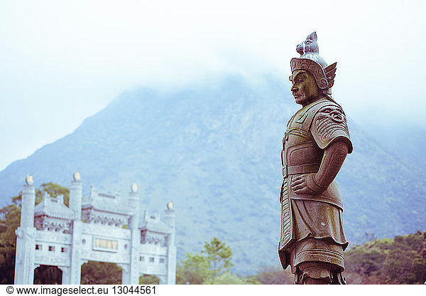 Statue gegen Berge