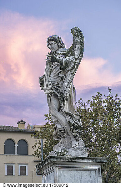 Statue of an angel with wings  dawn sky