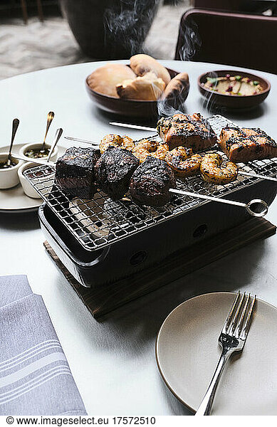 Steak  shrimp  and salmon kababs served table top over coals.