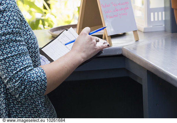 stehend einsteigen zeigen Stift Stifte Schreibstift Schreibstifte Mensch halten Cafe Rechnung Tresen Speisekarte Karte