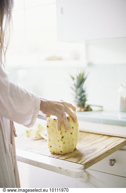 stehend Frau Frische schneiden Küche Ananas