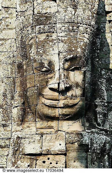 Steingesicht im Bayon-Tempel  Angkor  Kambodscha. Bayon liegt innerhalb der Mauern von Angkor Thom  einer 3 km² großen ummauerten Königsstadt und Tempelanlage  die im 12. und 13. Jahrhundert unter der Herrschaft von Jayavarman VII. erbaut wurde. Sie verfügt über fünf Eingänge - ein Nord-  Süd-  Ost- und Westtor und das Siegestor - sowie über eine Reihe berühmter Tempel  darunter der Bayon-Tempel  die Phimeanakas und die 350 m lange Elefantenterrasse.