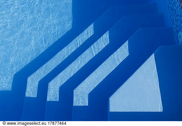 Steps in swimming pool on sunny day