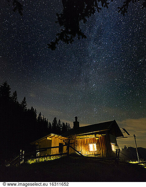 Sternenklarer Nachthimmel über einer einsamen Berghütte