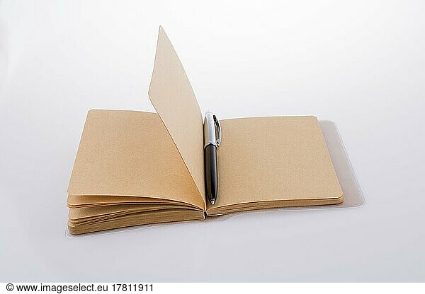 Stift auf einem Notizbuch auf weißem Hintergrund