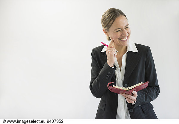 Stift Stifte Schreibstift Schreibstifte Geschäftsfrau lächeln halten schwarz Notizblock Notebook