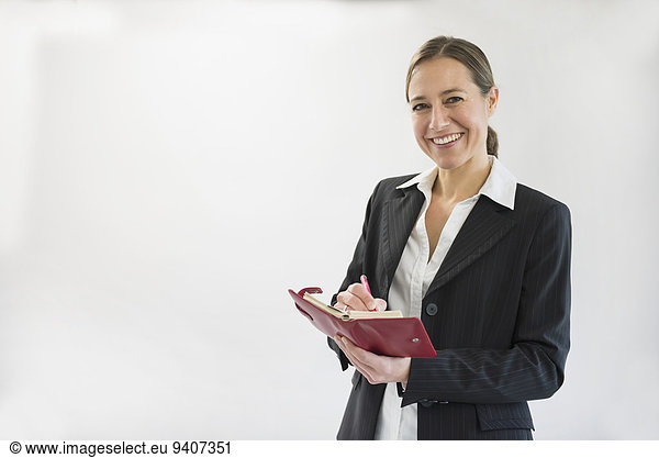 Stift Stifte Schreibstift Schreibstifte Portrait Geschäftsfrau lächeln halten schwarz Notizblock Notebook