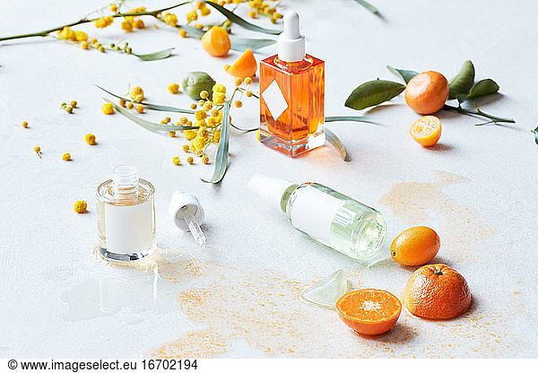 Still life display of skin care products with fruits and branches
