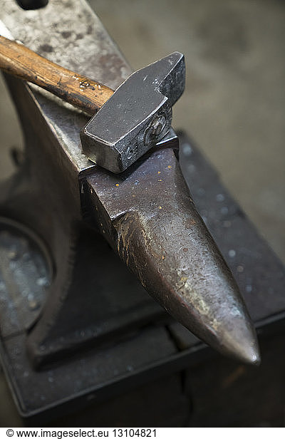 Still life of an anvil and a hammer in a blacksmith's metalwork shop.