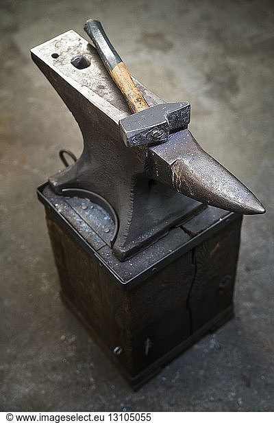 Still life of an anvil and a hammer in a blacksmith shop.