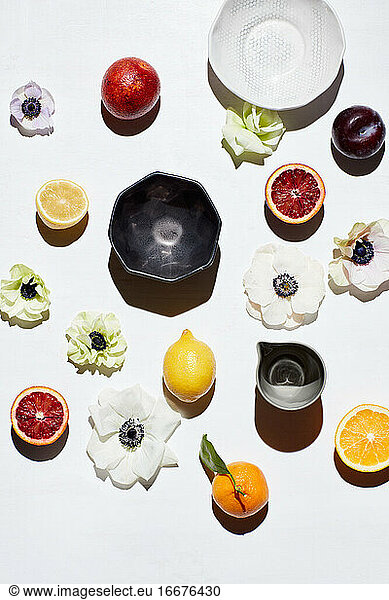 Still life of custom pottery bowls  fruits  flowers on surface