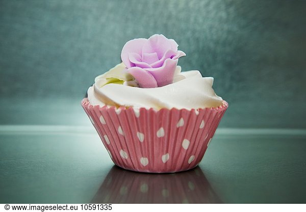 Still life of iced cupcake in pink spotted case