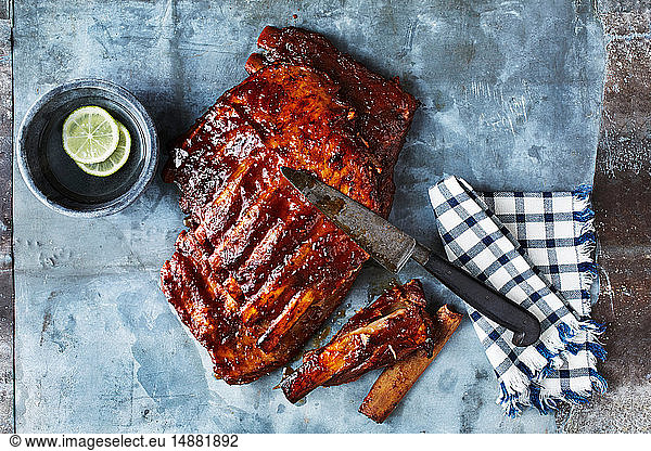 Still life with BBQ spare ribs and kitchen knife  overhead view