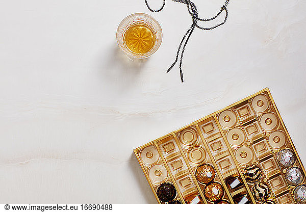 Still life with chocolate box  whiskey glass  necklace