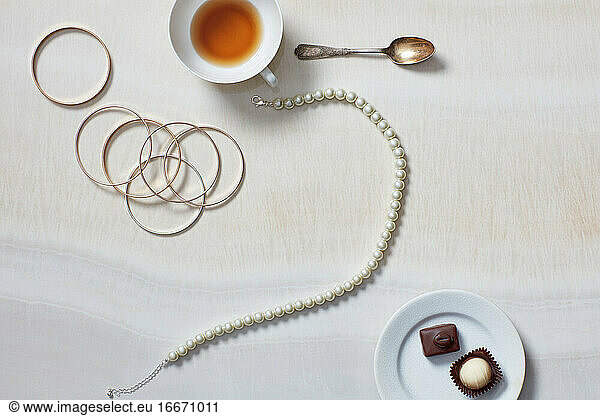 Still life with necklace  bracelet  tea  chocolates
