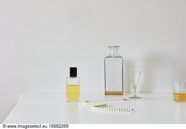Still life with perfume  whiskey  necklace