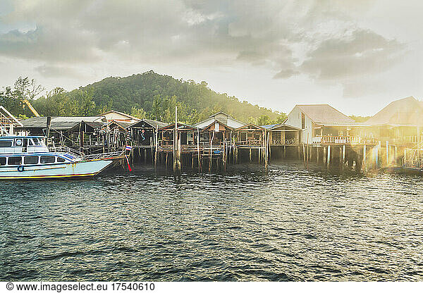 Stilt houses in front of mountain at sunset Ko Lanta Thailand