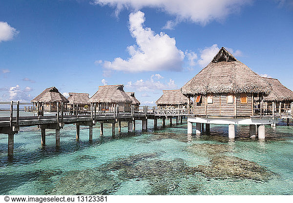 Stilt houses in lagoon of Bora Bora island sky during sunny day