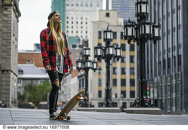 Stilvolle weibliche Millennials im städtischen Bereich mit Skateboard suchen