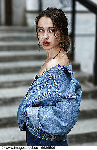 stilvolles Millennial-Mädchen mit schönen braunen Augen in einer Jeansjacke