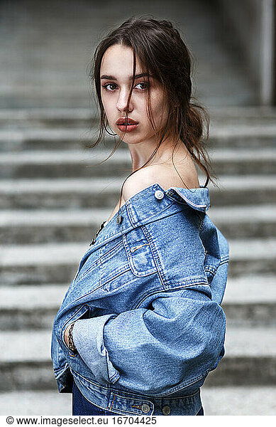 stilvolles Millennial-Mädchen mit schönen braunen Augen in einer Jeansjacke
