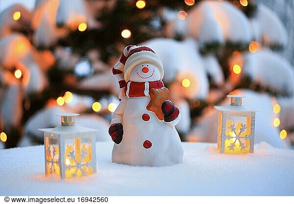 Stimmungsvolle Weihnachtsdekoration im Freien mit Schneemann  Laternen  Schnee und Lichterkette an Weihnachtsbaum