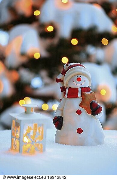 Stimmungsvolle Weihnachtsdekoration im Freien mit Schneemann  Laternen  Schnee und Lichterkette an Weihnachtsbaum