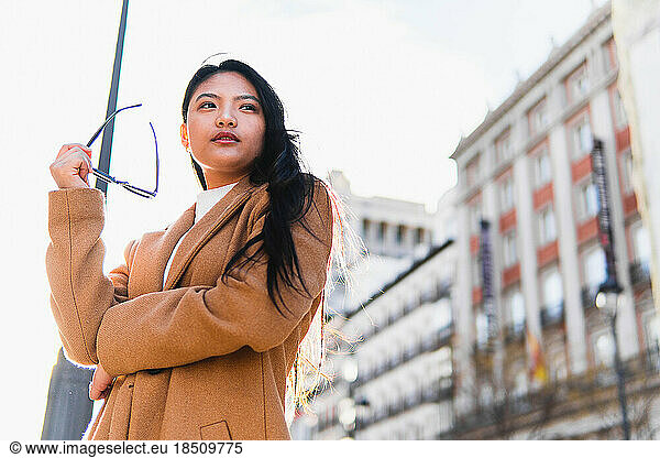 stock photo of business asian girl with glasses outdoors visiting city