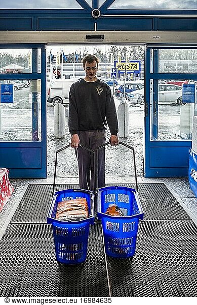Stockholm  Schweden Ein junger Mann mit zwei Einkaufskörben  gefüllt mit Zementsäcken.