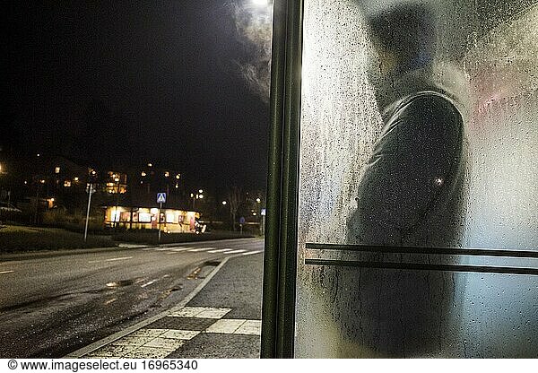 Stockholm  Schweden Ein Mann wartet im Regen auf einen Bus im Vorort Lidingo.