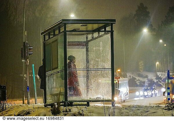 Stockholm  Schweden Eine Person wartet an einer Bushaltestelle im eiskalten Regen.