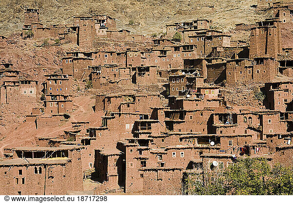 Stone and earth buildings built on a dramatic hillside in Magdaz  M'Goun Massif  Central High Atlas  Morocco.