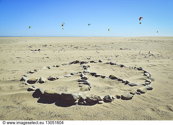 Stones arranged on sand Waddell Beach against clear blue sky