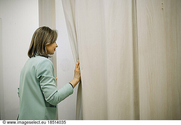 Store owner looking in fitting room