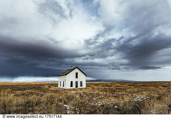 storm clouds loom over white abandoned house in desert  Colorado