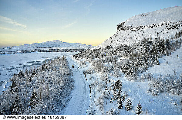 Straße bei verschneiten Bergen am Morgen