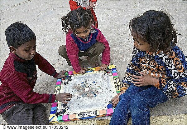 Straßenkinder in B?nares  hier besetzt von einigen Westlern  die ausschließlich nach B?nares kommen  um den Kindern zu helfen  indem sie sie z.B. mit Brettspielen beschäftigen  Chandra Ghat  B?nares  UP  Indien.