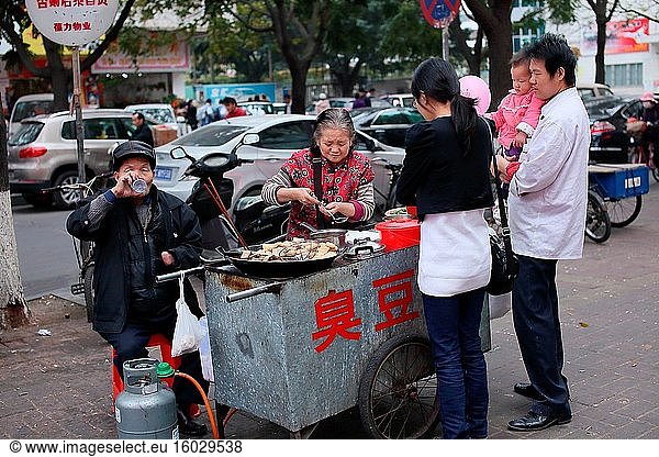 Straßenszene mit beleuchtetem Lebensmittelgeschäft  China