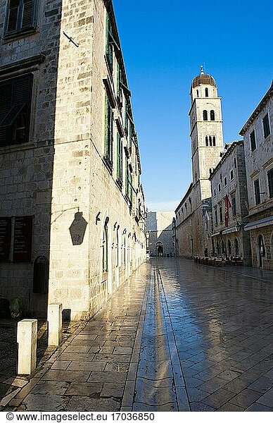 Stradun und das Franziskanerkloster am frühen Morgen  Altstadt von Dubrovnik  Kroatien. Dies ist ein Foto von Stradun  der Hauptstraße in der Altstadt von Dubrovnik früh am Morgen mit dem Franziskanerkloster im Hintergrund. Das Franziskanerkloster ist ein christliches Kloster aus dem 14. Jahrhundert und befindet sich auf dem Stradun  der berühmten Hauptstraße in der Altstadt von Dubrovnik.