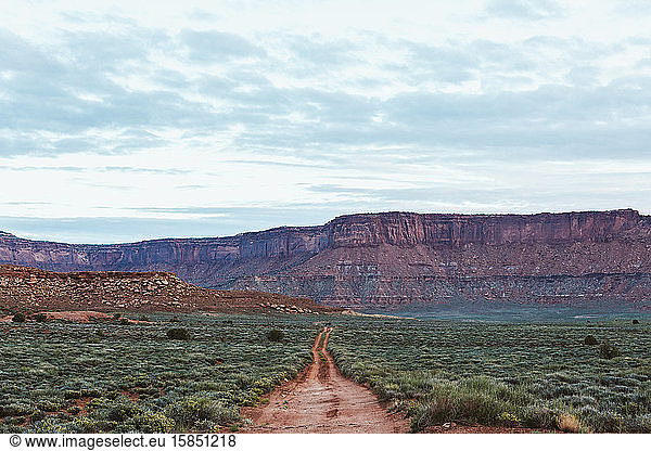 straight red two track dirt road headed off to nowhere in utah desert