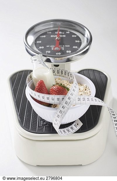 Strawberries  milk  cereal and tape measure on scales