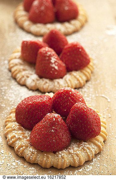 Strawberry tartlet on chopping board  close up