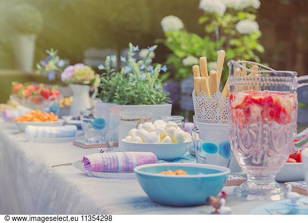 Strawberry water and desserts on garden party patio table