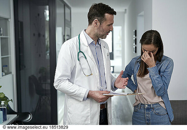 Stressed woman discussing with doctor at clinic
