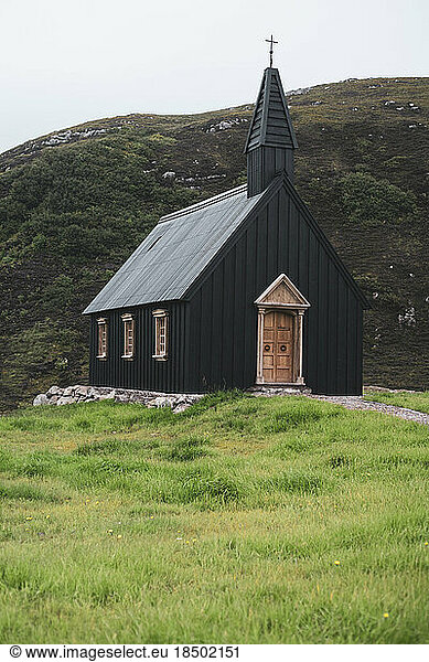 striking black wood church sits on wild hillside in remote scotland