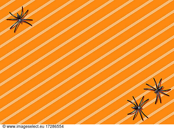 Striped Halloween background with spiders in corners