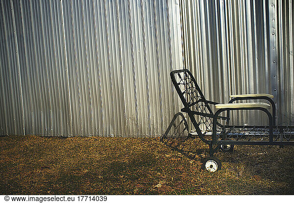 Stripped Lawn Chair gegen eine Metallhangarwand; Maricourt  Quebec  Kanada