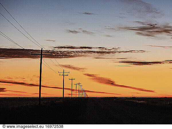 Stromleitung  die bei Sonnenaufgang im Mittleren Westen der USA in die Ferne rückt